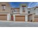 Stylish townhome showcasing a two-car garage, modern architecture, and a red front door at 11904 Glide Reflection Ave, Las Vegas, NV 89138