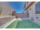 Private backyard featuring artificial turf, a brick patio, and a tall brick privacy wall at 11922 Glide Reflection Ave, Las Vegas, NV 89138