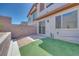Cozy backyard with artificial turf, a brick patio, and a privacy wall, perfect for outdoor entertaining at 11922 Glide Reflection Ave, Las Vegas, NV 89138