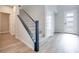 Bright entryway featuring gray laminate flooring, white walls, stairs with black accents at 11922 Glide Reflection Ave, Las Vegas, NV 89138