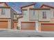 Modern townhomes with stone accents, brown garages, and eye-catching orange front doors at 11922 Glide Reflection Ave, Las Vegas, NV 89138