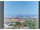 Breathtaking city view from a window, showcasing the skyline and distant mountains, complemented by a beautiful neighborhood at 12290 Terrace Verde Ave, Las Vegas, NV 89138