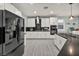 Modern kitchen with white cabinets, stainless steel appliances, black backsplash, and wood-look tile flooring at 12290 Terrace Verde Ave, Las Vegas, NV 89138