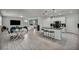 Open-concept living space with wood-look tile flooring, modern furniture, and a sleek kitchen island at 12290 Terrace Verde Ave, Las Vegas, NV 89138