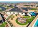 Lovely backyard featuring a pool, hot tub, fire pit with swing set, lush landscaping, and solar panels at 129 Major Bowling Pl, Henderson, NV 89011
