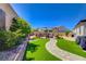Lush backyard oasis with a custom swing set, artificial grass, and a beautiful walkway at 129 Major Bowling Pl, Henderson, NV 89011