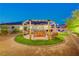 An outdoor lounge area with a wooden gazebo, swing benches, and manicured landscaping at 129 Major Bowling Pl, Henderson, NV 89011