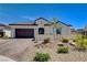 Well-manicured front yard with desert landscaping, featuring a stucco home with brick driveway and dark brown garage at 129 Major Bowling Pl, Henderson, NV 89011
