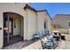 Inviting front porch with an iron gate, two rocking chairs and a table, and a brick paved patio at 129 Major Bowling Pl, Henderson, NV 89011