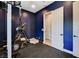 Home gym with weight rack, weights, and cardio machine with a blue accent wall at 129 Major Bowling Pl, Henderson, NV 89011