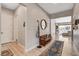 Hallway featuring light wood flooring, a cozy bench, decorative mirror, and access to the living area at 129 Major Bowling Pl, Henderson, NV 89011