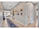 Hallway features light wood flooring, neutral walls adorned with art, and access to the home's living spaces at 129 Major Bowling Pl, Henderson, NV 89011