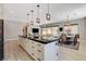 Open-concept living and dining area featuring a large kitchen island with bar seating and modern lighting at 129 Major Bowling Pl, Henderson, NV 89011
