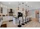 Bright kitchen features white cabinets, a center island with bar seating and modern pendant lighting at 129 Major Bowling Pl, Henderson, NV 89011