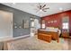 Bright main bedroom features a ceiling fan, hardwood floors, and ensuite bathroom entrance at 129 Major Bowling Pl, Henderson, NV 89011