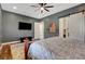 Large main bedroom with a barn door leading to the bathroom, tv, and natural lighting at 129 Major Bowling Pl, Henderson, NV 89011