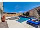 Lush backyard showcasing a sparkling pool, sunken fire pit, and comfortable lounging areas for relaxation at 129 Major Bowling Pl, Henderson, NV 89011