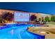 Backyard pool with an outdoor movie screen, a waterfall feature, and lush landscaping at 129 Major Bowling Pl, Henderson, NV 89011