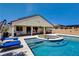 Backyard with a stunning pool, sunken fire pit, and outdoor seating ideal for relaxation and entertainment at 129 Major Bowling Pl, Henderson, NV 89011