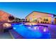 Inviting backyard with an illuminated pool, fire pit, and a covered patio for outdoor living at 129 Major Bowling Pl, Henderson, NV 89011