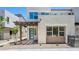 Modern two-story home features a covered entry, blue door, gray gravel landscaping and a second story patio at 1491 Melodic Lark Dr, Las Vegas, NV 89138