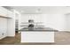 This sleek kitchen boasts modern appliances, white cabinetry, and a contrasting island with dark countertop at 1491 Melodic Lark Dr, Las Vegas, NV 89138