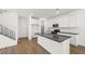 A modern kitchen features white cabinets, stainless appliances, a gray backsplash, and a dark countertop island at 1491 Melodic Lark Dr, Las Vegas, NV 89138