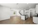 Spacious living area with a modern kitchen island, wood-look tile flooring, and staircase to the upper level at 1491 Melodic Lark Dr, Las Vegas, NV 89138