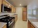 A modern kitchen featuring stainless steel appliances, granite countertops, and wooden cabinets at 2132 Tierra Del Verde St, Las Vegas, NV 89156