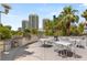 Outdoor grilling area with multiple grills, tables, chairs, and mature landscaping for entertaining guests at 222 Karen Ave # 3305, Las Vegas, NV 89109