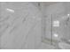 This bathroom features a sleek, frameless glass shower and modern fixtures and a marble-style tile surround at 2305 W Horizon Ridge Pkwy # 611, Henderson, NV 89052