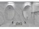 This bathroom showcases double sinks, oval mirrors, stylish fixtures and elegant marble-style tile at 2305 W Horizon Ridge Pkwy # 611, Henderson, NV 89052