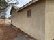 Exterior side view of the home showing stucco and windows at 2451 E Falcon St, Pahrump, NV 89048