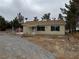 Cozy single-story home with a gravel yard, mature trees, and a functional satellite dish at 2451 E Falcon St, Pahrump, NV 89048