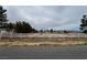 Large lot with mature trees, a white fence, a home, and views of the local mountains at 2451 E Falcon St, Pahrump, NV 89048