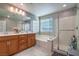 Well-lit bathroom features double sinks, a soaking tub, and a separate glass-enclosed shower at 2787 Donatello Manor Pl, Henderson, NV 89044