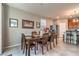 Dining room features a wooden table, six chairs, and view into kitchen area at 2787 Donatello Manor Pl, Henderson, NV 89044