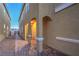 Inviting walkway to front door of a neutral colored home with arched porch and desert landscaping at 2787 Donatello Manor Pl, Henderson, NV 89044