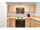 Kitchen features light wooden cabinetry, laminate countertops and black appliances at 2851 S Valley View Blvd # 1120, Las Vegas, NV 89102