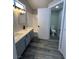 Bathroom featuring double vanity sinks with gray cabinets, a shower-tub combo, and a toilet room at 3238 Canyon Terrace Dr, Laughlin, NV 89029
