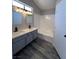 Bathroom featuring double vanity sinks with gray cabinets and a shower-tub combo at 3238 Canyon Terrace Dr, Laughlin, NV 89029