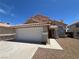 Charming two-story home featuring a tile roof, well-maintained landscaping, and a two-car garage at 3238 Canyon Terrace Dr, Laughlin, NV 89029