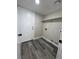 A practical laundry room featuring gray wood floors, white walls, and upper cabinet space at 3238 Canyon Terrace Dr, Laughlin, NV 89029