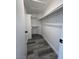 Bright, white walk-in closet features built-in shelving and gray wood flooring at 3238 Canyon Terrace Dr, Laughlin, NV 89029
