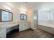 Bright bathroom featuring dual sinks, soaking tub, walk-in shower, and modern fixtures at 3241 E Winery Rd, Pahrump, NV 89048