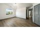 Bedroom features wood floors, a modern chandelier, and large windows with natural light at 3241 E Winery Rd, Pahrump, NV 89048