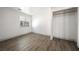 Bright bedroom with wood floors, window, and walk-in closet featuring baseboards and neutral walls at 3241 E Winery Rd, Pahrump, NV 89048