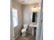 A neutral half-bath with a pedestal sink and wood-look floors, offering a convenient space at 3617 Austell St, Las Vegas, NV 89129