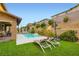 Backyard with a sparkling pool, water feature, lounge chairs, and lush landscaping at 391 Capistrano Vistas St, Las Vegas, NV 89138