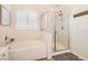 Bright bathroom with glass enclosed shower, tub, and shuttered windows at 391 Capistrano Vistas St, Las Vegas, NV 89138